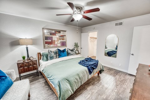 the master bedroom has a large bed and a ceiling fan